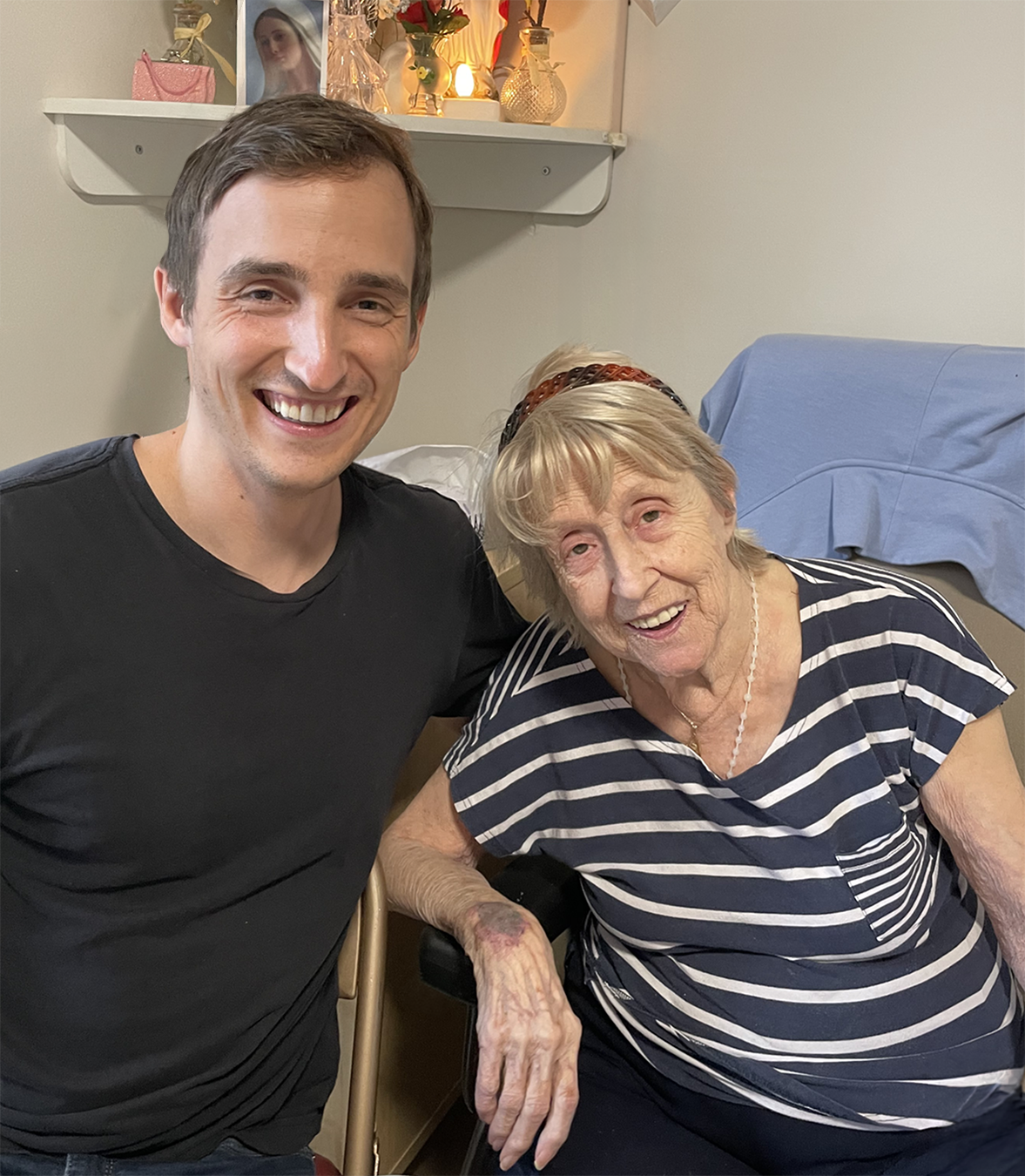 Tony Aubé and his grandmother smiling together at home.
