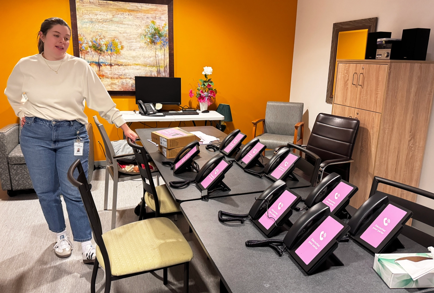 A full row of Amical phones ready to be installed at Groupe Santé Arbec, with an Amical employee.