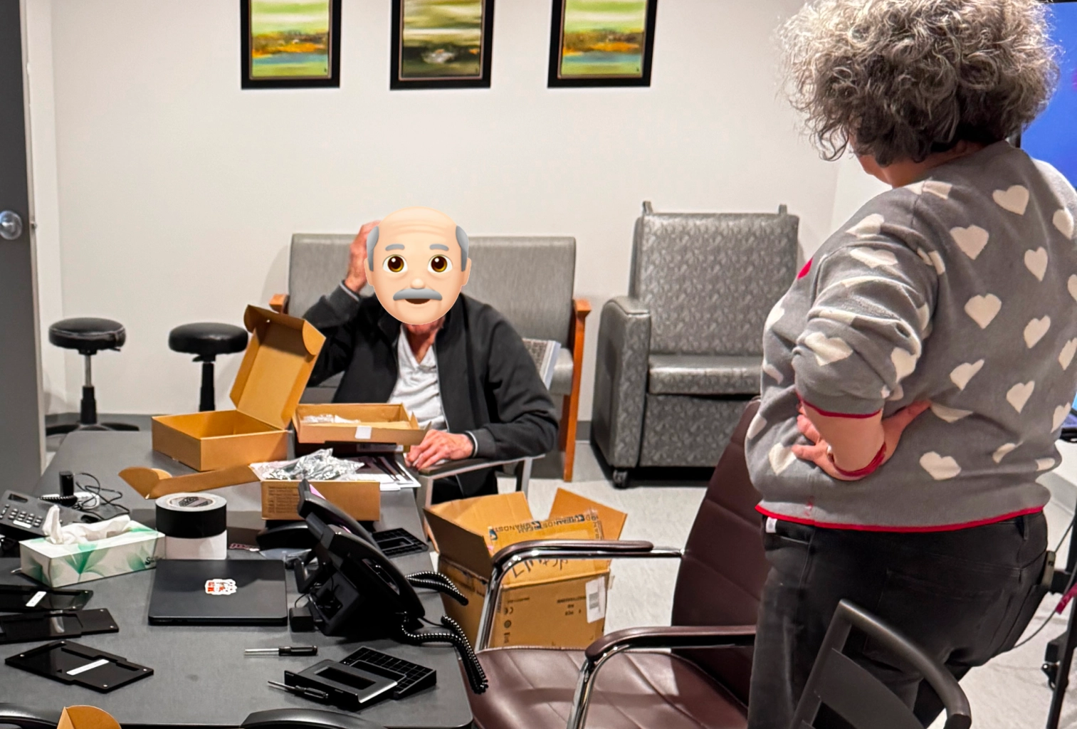 A resident, face hidden to protect their anonymity, helps the Amical team manage the boxes during setup.